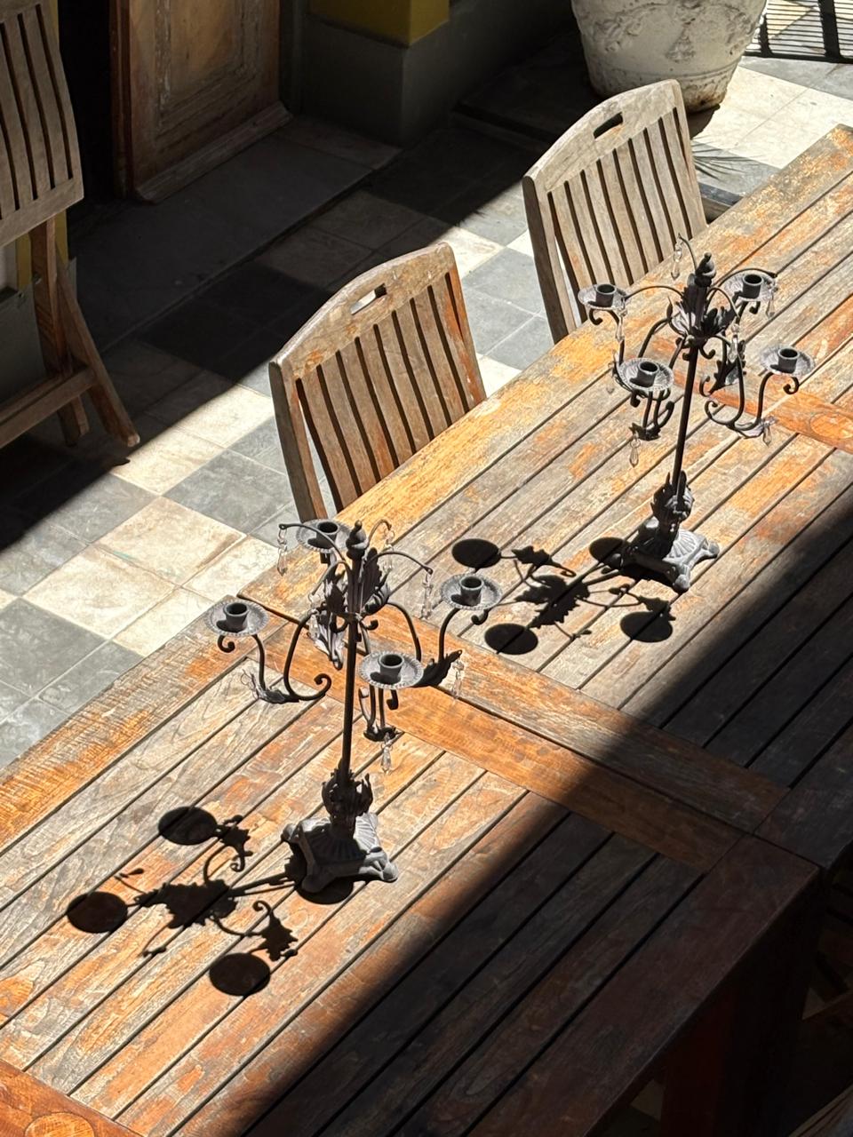 Mesa compartida de madera con candelabros en el patio