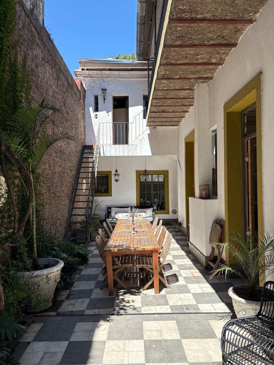 Patio principal visto desde arriba, con vegetación, mesas y sillones